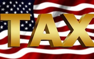 Gold TAX text on a US flag background
